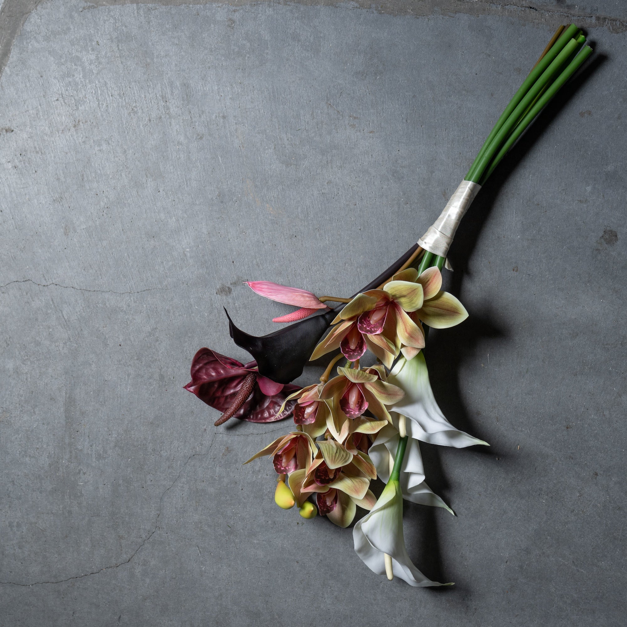 シンビジュームとカラーのスタイリッシュな縦長ブーケ