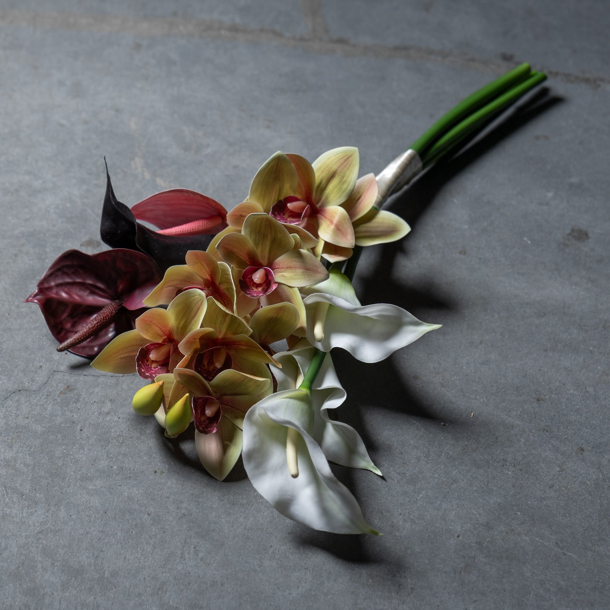 シンビジュームとカラーのスタイリッシュな縦長ブーケ