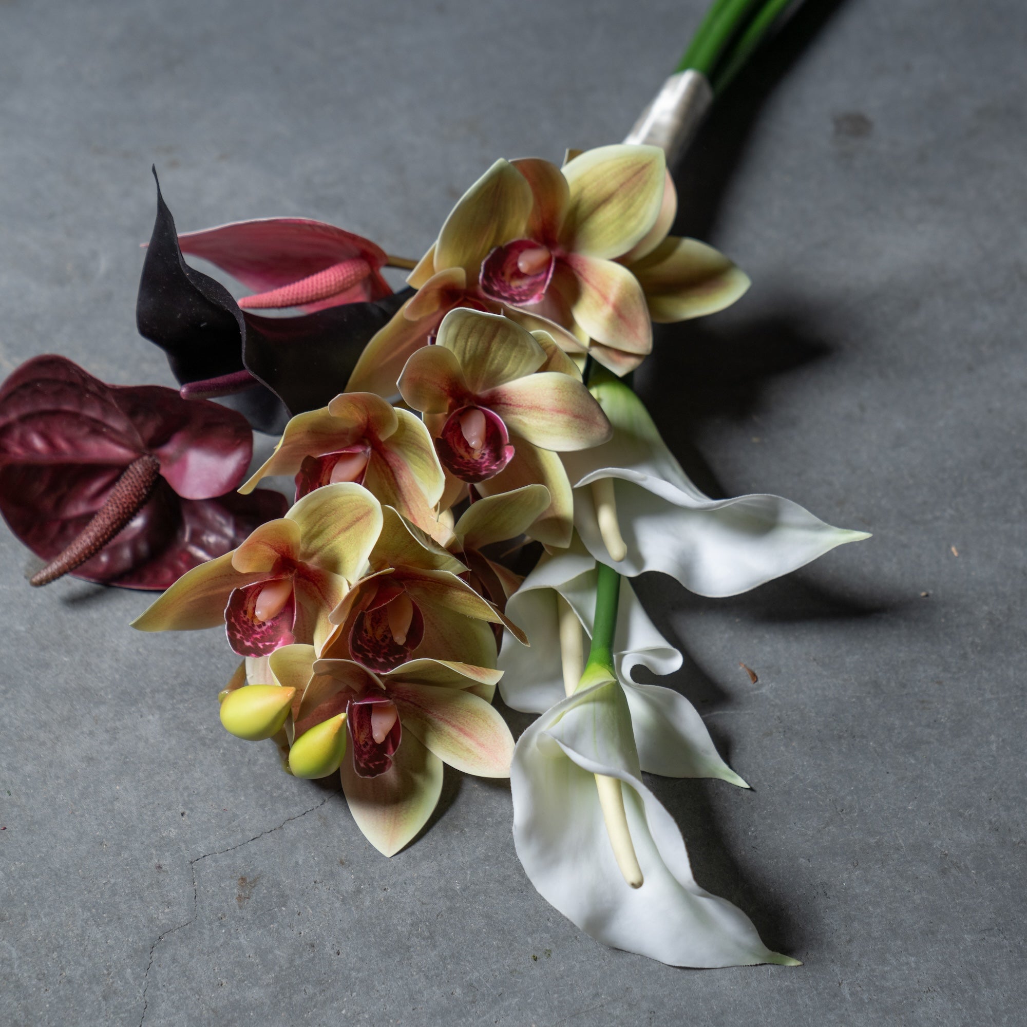 シンビジュームとカラーのスタイリッシュな縦長ブーケ